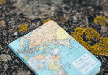Open travel journal with photos, tickets, and handwritten notes